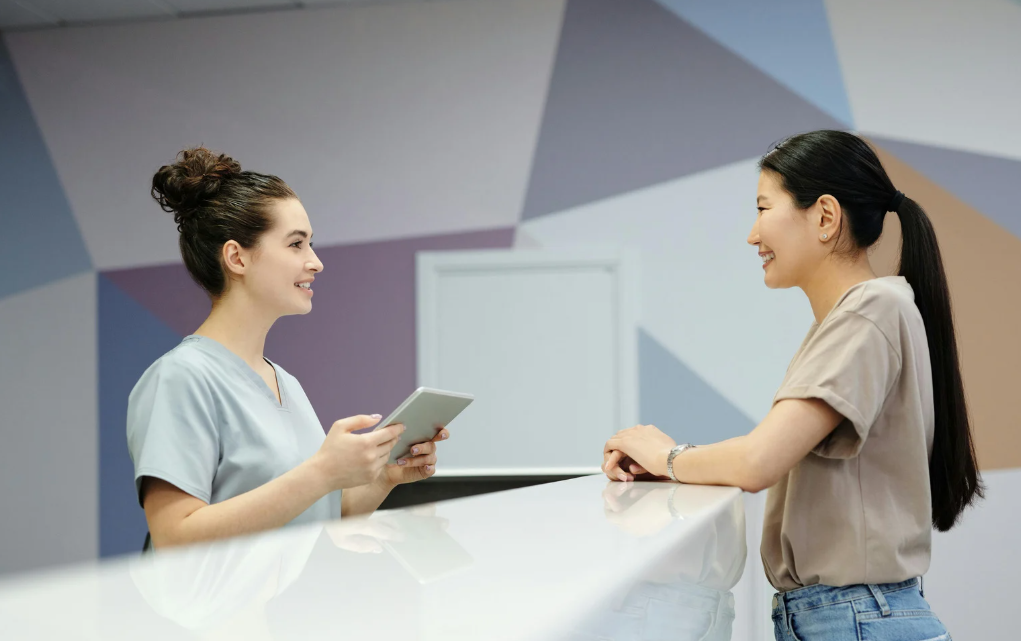 Dental assistant speaking with a patient before treatment in a dental clinic.