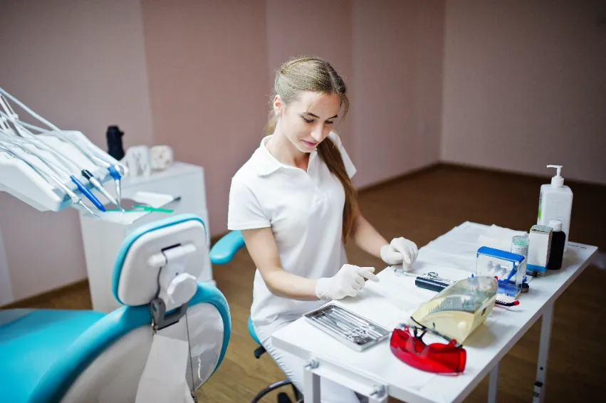 Dental assistant preparing tools in a dental clinic.
