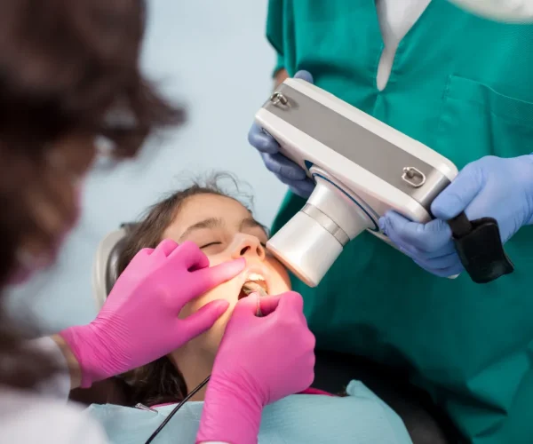 Orthodontic assistant taking dental X-rays to support orthodontic treatment.