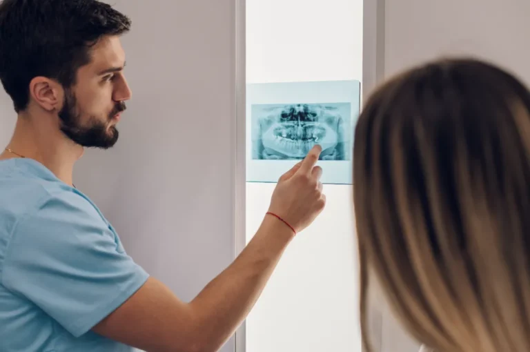 A dentist teaching a dental assisting school student how to read X-rays.