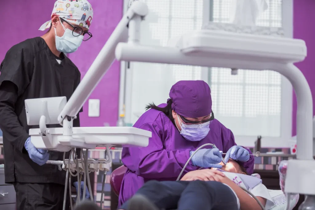 dentist and dental assistant wearing full PPE during a patient procedure.