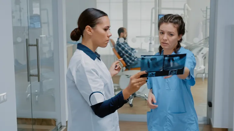 Dental assistant discussing X-ray with a dentist.